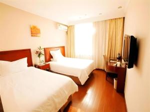 a hotel room with two beds and a television at GreenTree Alliance Changzhou University City Hotel in Changzhou +88 photos