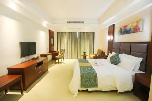 a hotel room with a large bed and a television at Qionghai Jin Mao Hotel in Qionghai