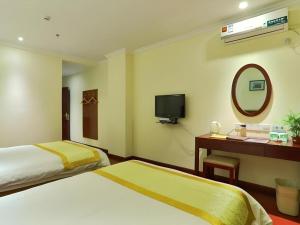 a hotel room with two beds and a mirror at GreenTree Inn Nanjing Software Valley DaDingFang Express Hotel in Nanjing