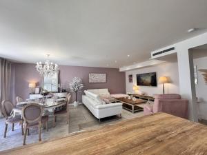 Una sala de estar con un sofá y un comedor. en La Bella Rosa - Direct circuit - Piscine - Climatisation, en Le Mans