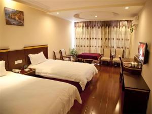 a hotel room with two beds and a table and chairs at GreenTree Inn Shanghai Minhang Development Zone Subway Station Business Hotel in Shanghai +150 photos