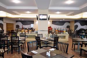 a dining room with tables and chairs and a restaurant at Grand Daira Hotel Palembang in Palembang