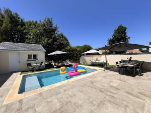 Una piscina con un juguete de piscina en un patio trasero. en La Bella Rosa - Direct circuit - Piscine - Climatisation, en Le Mans