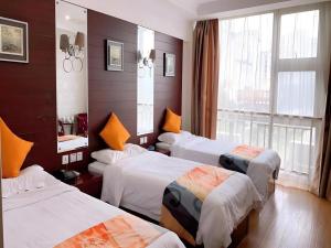 Una habitación de hotel con tres camas y una ventana. en Shell Suzhou Exhibition Center Huning Chengtie Zone Station Jinfeng Square, en Suzhou