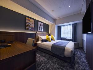 a hotel room with a bed and a desk at Hotel Villa Fontaine Kobe Sannomiya in Kobe