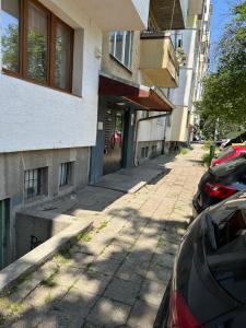 a street with cars parked in front of a building at Апартамент Миели by Flat Manаger in Sofia