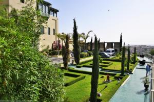 - une vue sur un jardin planté de palmiers et un bâtiment dans l'établissement Palais Faraj Suites & Spa, à Fès