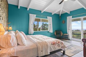 Schlafzimmer mit einem Bett mit blauen Wänden und Fenstern in der Unterkunft Mala o Kilauea Nature Retreat in Pahoa