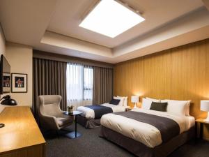 a hotel room with two beds and a chair at Hotel Denim Seoul in Seoul +193 photos