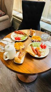比什凯克Astor Hotel & Spa的一张木桌，上面摆放着食物盘子