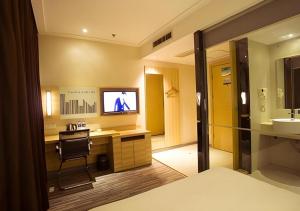 La salle de bains est pourvue d'une télévision et d'un bureau avec un lavabo. dans l'établissement City Comfort Inn Huangshi City Huangshi Avenue, à Huangshi