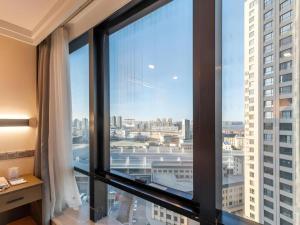 a room with a large window with a view of a city at Dalian Bohai Pearl Hotel in Dalian