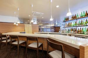 a restaurant with a bar with chairs and bottles at Art Hotel Niigata Station in Niigata