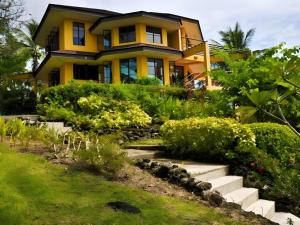 a yellow house with stairs in front of it at Ticao Altamar Boutique Resort in Tahiran