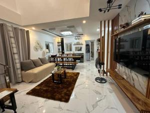 a living room with a couch and a tv at Casa MiKulai in Aliang