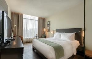 a hotel room with a large bed and a television at The Mirador in Mumbai +133 photos