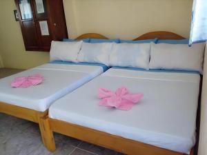 two beds with pink flowers on top of them at Golden Sam Resort and Restaurant in Panglao