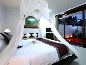 a bedroom with a white bed with mosquito netting at Evita Villas in Ubud +143 photos