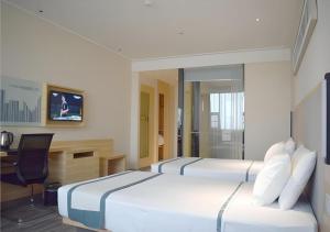 a hotel room with two beds and a desk at City Comfort Inn Meishan Sansu Temple in Meishan