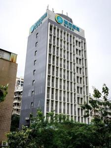WuzhouにあるCity Comfort Inn Wuzhou Wangcheng Squareの青い看板が付いた背の高い白い建物