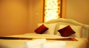 a bedroom with a bed with two red pillows at Green Home Resort in Surat Thani
