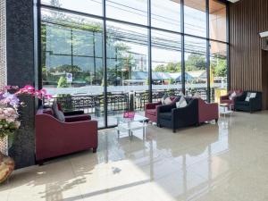 a lobby with couches and tables and large windows at Viva Residence in Ban Baen Phichit