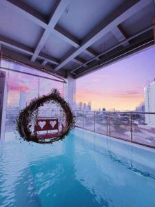 a large swimming pool in a building with a large window at G Suites Hotel By AMITHYA in Surabaya