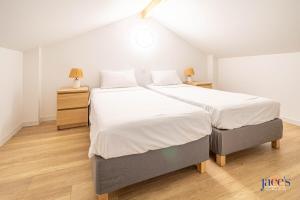 a bedroom with a large bed with white sheets at La charmante Albertine villa proche port in Arcachon