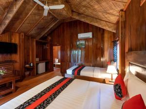 a bedroom with a bed in a room with wooden walls at Amour D' Angkor in Phumĭ Réach Born (1)