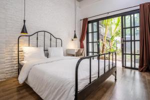 Un dormitorio con una cama blanca y una ventana grande. en 5BR Villa Naga Sanur, en Sanur