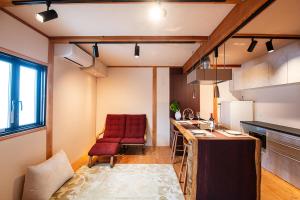 a kitchen with a red chair and a kitchen counter at MIYABI Guesthouse in Hakusan