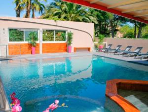 a swimming pool with two dolls in the water at Hotel & Spa Gil de France Cap d'Agde in Cap d'Agde