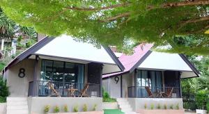 a house with chairs on the balcony of it at Rim Kaeng resort in Phetchaburi