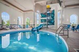 a swimming pool with a slide in a building at Days Inn & Suites by Wyndham Winkler in Winkler