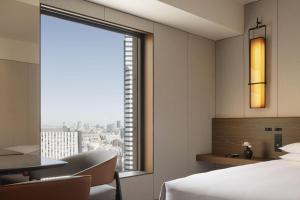 a hotel room with a bed and a desk and a window at Hyatt Regency Tokyo in Tokyo