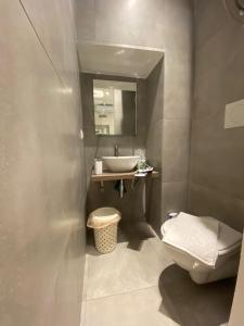 a bathroom with a sink and a toilet and a mirror at AmaRé House in Bari