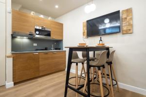 Una cocina con una mesa y taburetes en una habitación. en Cozy Studio in the Oltrarno Area, en Florencia