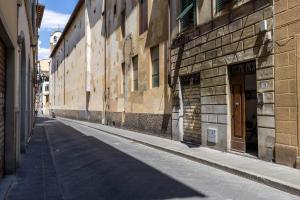 una calle vacía en un callejón con edificios en Cozy Studio in the Oltrarno Area, en Florencia