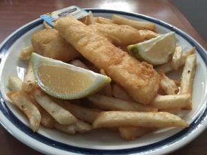 a plate of french fries with a lime and a lemon wedge at Boggabilla Motel in Boggabilla
