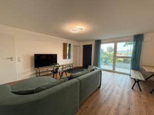a living room with a couch and a flat screen tv at Ferienwohnung Seezeit in Bodman-Ludwigshafen