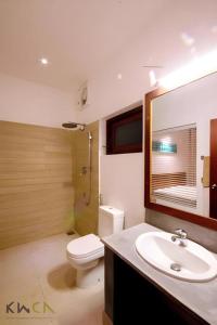 a bathroom with a white toilet and a sink at Neem Villas in Tanjanagaram