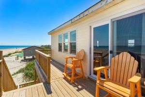 two chairs on a deck with a view of the beach at 7143 - Geri's Place #4 in Wanchese +44 photos