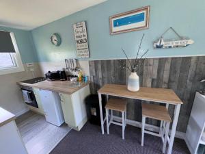 a kitchen with a table and a small table with chairs at 12 the glade in Kilkhampton