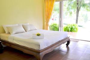 a bedroom with a bed with a flower box on it at At Home Suanphung in Ratchaburi