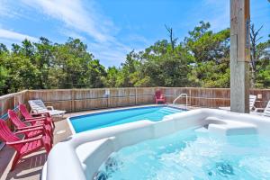 a swimming pool with two lawn chairs and a deck with at 1702 - Sandpiper Lookout in Poplar Branch