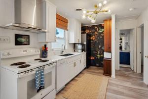a kitchen with white cabinets and a stove top oven at 5041 - The Captains Quarters in Kill Devil Hills