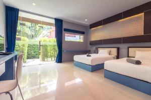 a bedroom with two beds and a large window at Sea Suite Villa in Chaweng