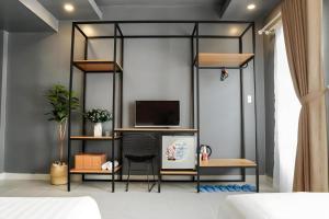 a room with a bed and a desk and a tv at Hoang Anh Hotel Vung Tau in Vung Tau