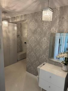 a bathroom with a sink and a mirror on a wall at AKOYA APARTMENT Cristal Bianco in Koszalin +37 photos