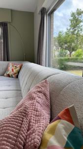 a bed with a blanket and a window in a room at Villa 't Zonneroosje in Nieuwpoort